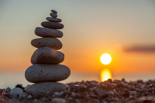cairn stacked rocks with sunset in the background